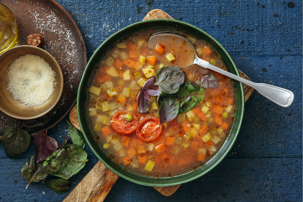 Vegan Minestrone soup on dark blue background. Top view.