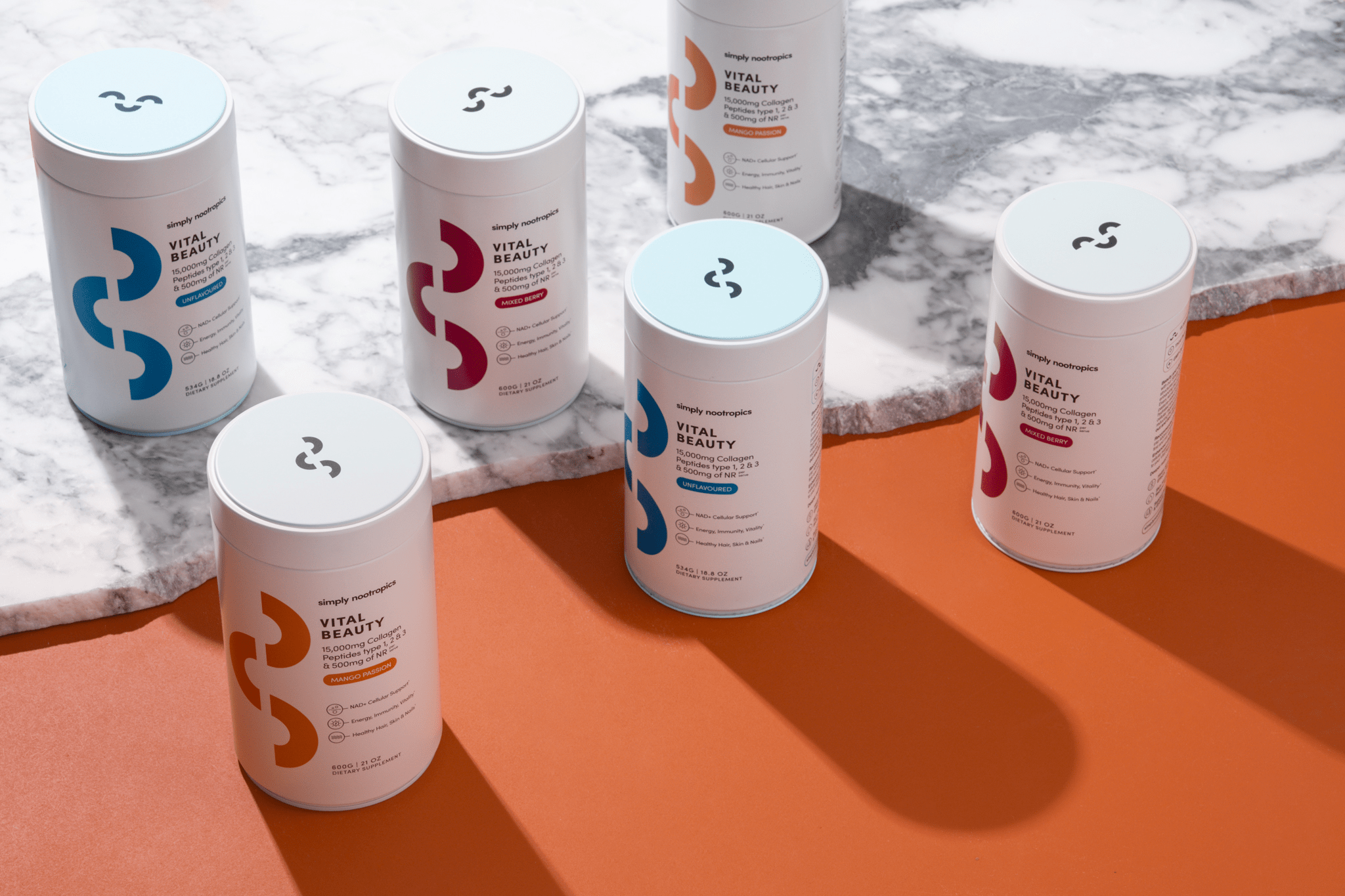 Simply Nootropics Vital Beauty Collagen Powder containers displayed on a marble and orange background.