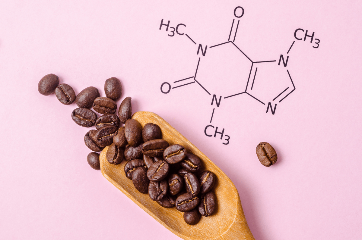 Coffee beans on a wooden spoon with a caffeine molecule diagram.