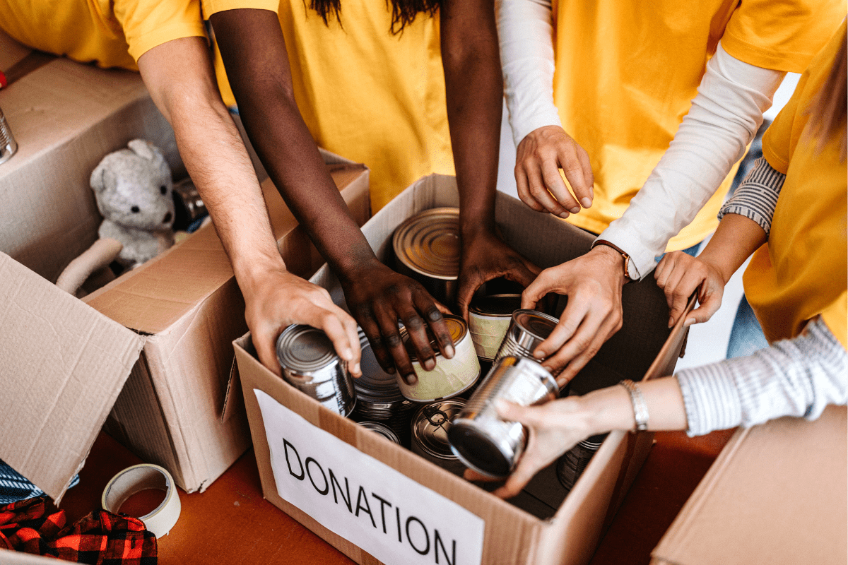 People packing canned goods into donation boxes.