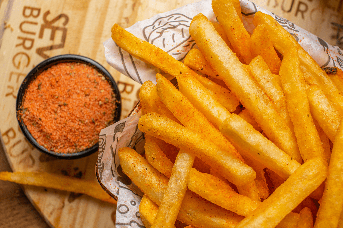 Close-up of seasoned French fries with dipping spice.