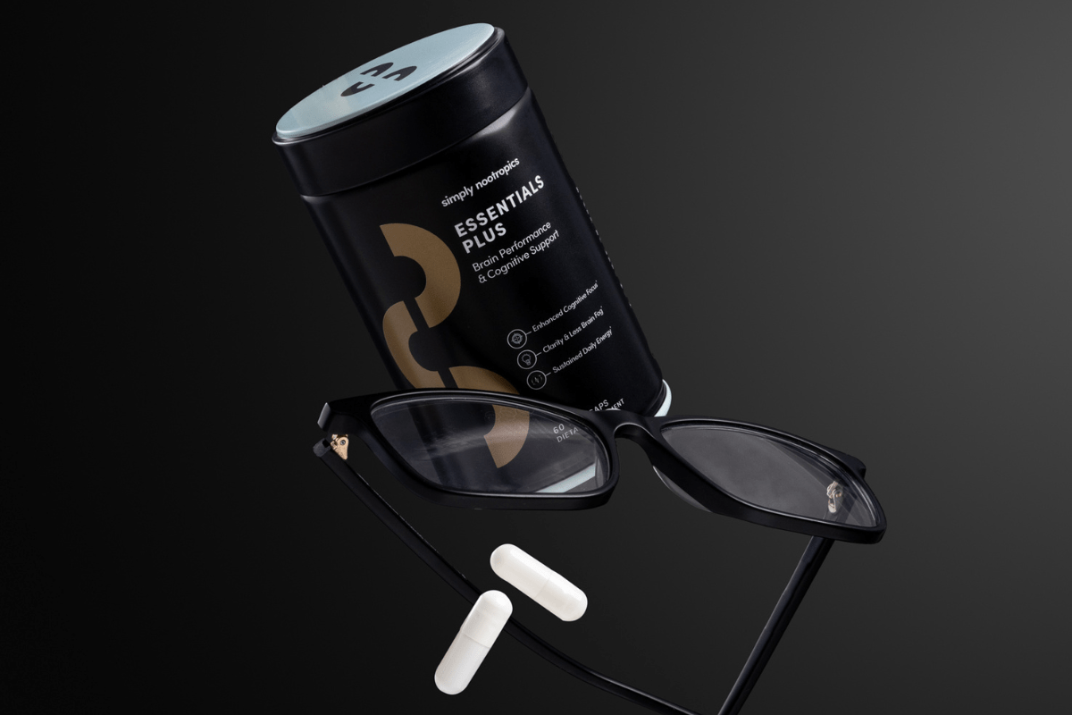 Essentials Plus supplement with two capsules and black glasses.