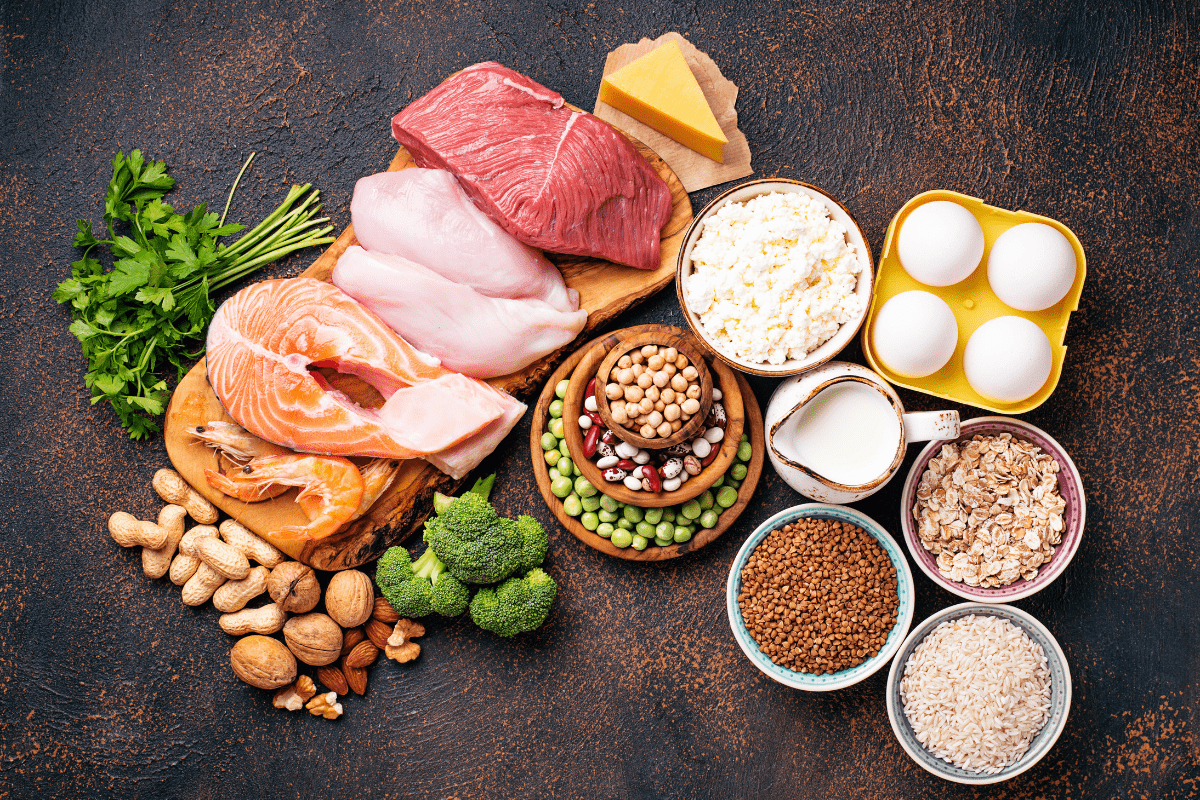 A variety of protein-rich foods displayed on a dark rustic background.